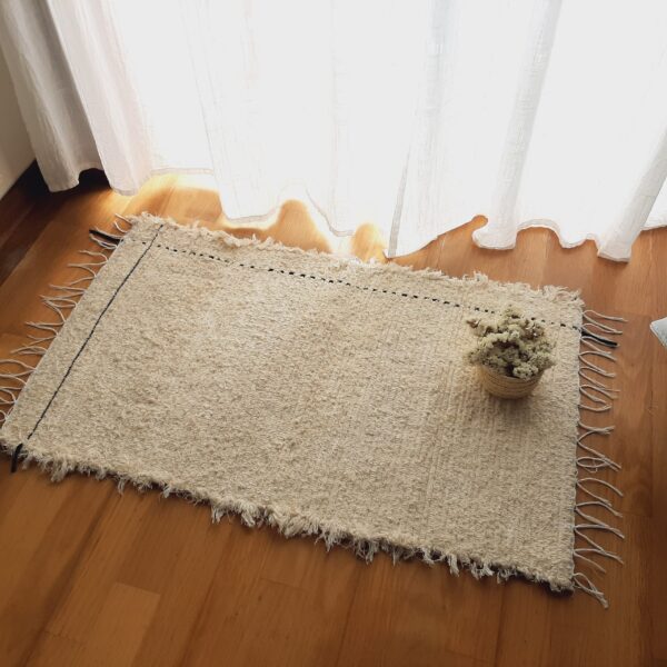 small cream rug with black line L
